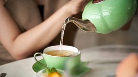 Kobieta nalewa herbatę z dzbanka