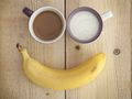 Banan i dwa kubki z napojami