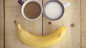 Banan i dwa kubki z napojami