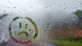 Smutna buźka na zaparowanej szybie