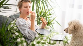 Kobieta leży w łóżku z tabletem i je