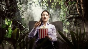 Kobieta ogląda film z popcornem w rękach