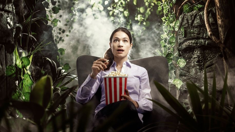 Kobieta ogląda film z popcornem w rękach