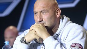 Marcin Najman z zamyśloną miną. W tle kontury innych osób.