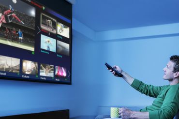 Mężczyzna ogląda telewizję - materiał poglądowy