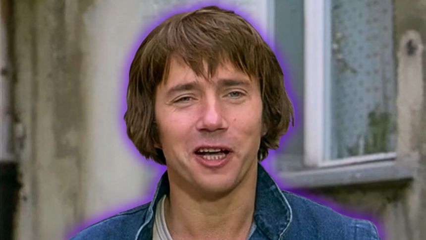 Uśmiechnięty mężczyzna na tle kamienicy