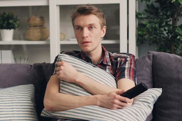 Mężczyzna ogląda telewizję - materiał poglądowy