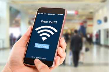 Ręce trzymające telefon, który łączy się z Wi-Fi