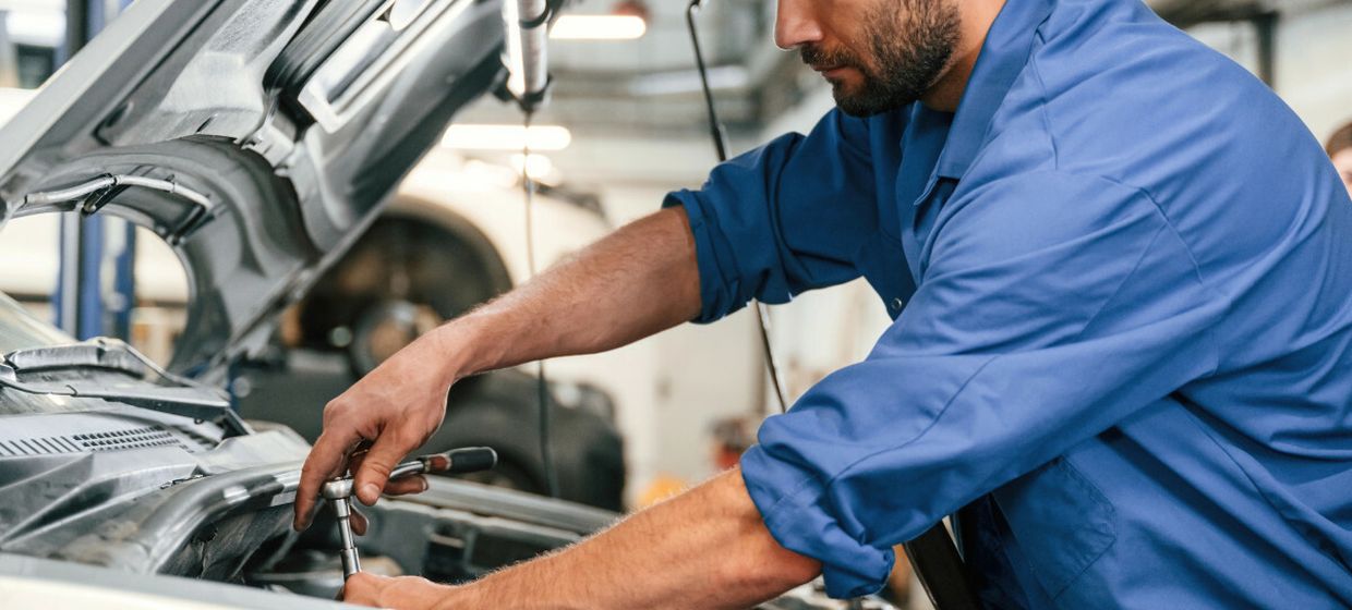 Mechanik naprawiający samochód - materiał poglądowy