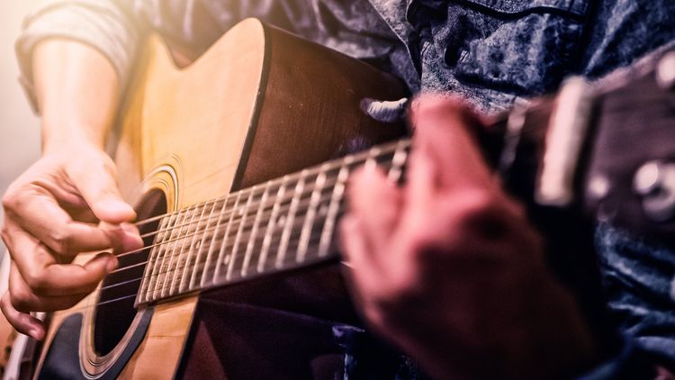 Mężczyzna gra na gitarze akustycznej