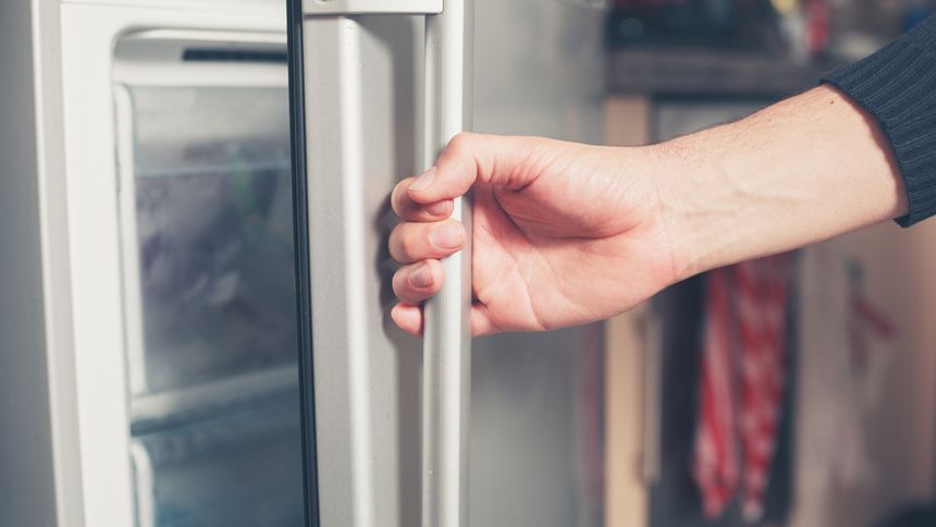 Ręka otwiera lodówkę - materiał poglądowy
