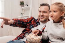 Ojciec i córka oglądają telewizję - materiał poglądowy