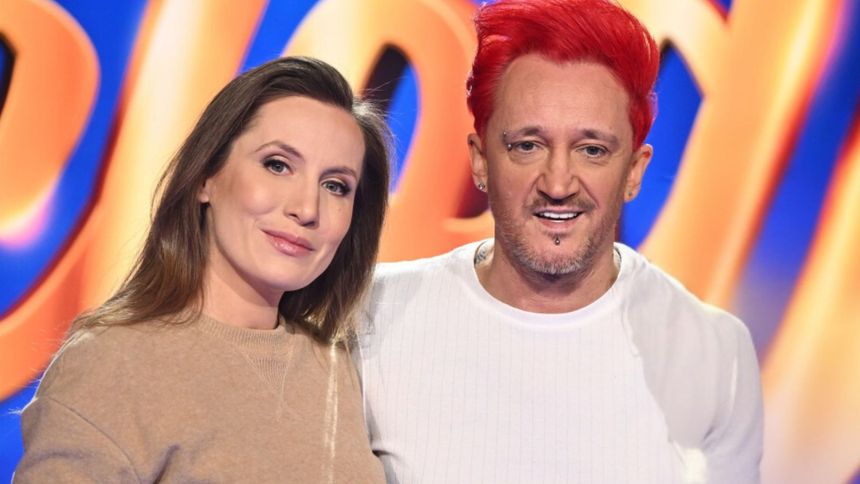Na zdjęciu para na planie telewizyjnym, mężczyzna z czerwonymi włosami, kobieta uśmiechnięta