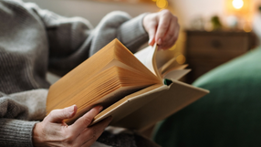 osoba siedzi na kanapie i czyta ksiazke