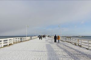 turysci na sopockim molo w zimowej scenerii.