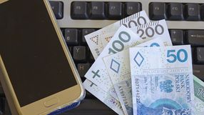 Klawiatura komputera, banknoty o roznym nominale i smartfon