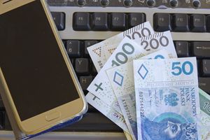 Klawiatura komputera, banknoty o roznym nominale i smartfon