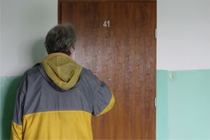 mężczyzna pukający do drzwi