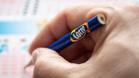 Dlon z olowkiem Lotto zanaczajaca liczby na kuponie