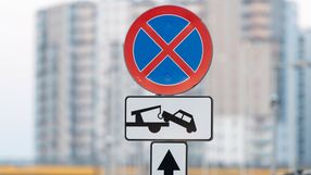 znak zakaz zatrzymywania sie i blok mieszkalny w tle
