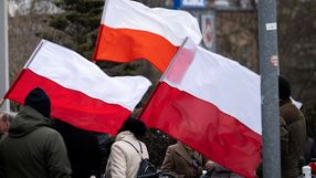 osoby z polskimi flagami