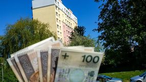 pieniądze w ręku na tle bloku mieszkalnego