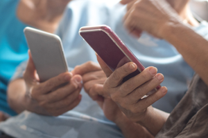 kobiety trzymają w dłoniach telefony komórkowe 