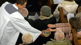 ksiądz zbierający na tacę