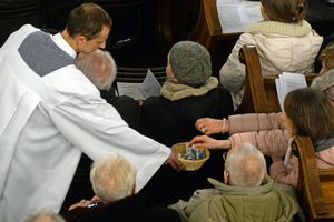 ksiądz zbierający na tacę