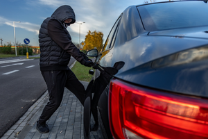 złodziej okrada samochód