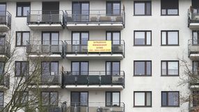 blok mieszkalny z ogłoszeniem o sprzedaży mieszkania