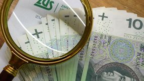 pieniądze, lupa i koperta z logo ZUS
