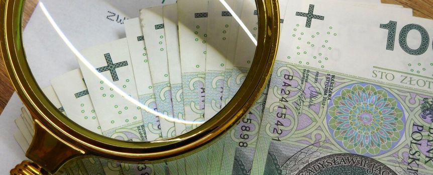 pieniądze, lupa i koperta z logo ZUS
