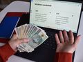 pieniądze w ręku przed ekranem komputera