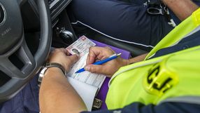 Policja wypisuje mandat kierowcy 