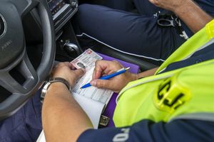 Policja wypisuje mandat kierowcy 