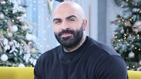 Akop Szostak w czarnej bluzie siedzi w studiu 