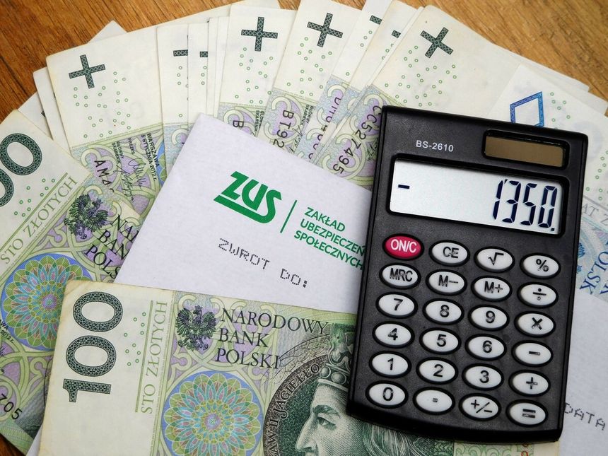 pieniądze, kalkulator i koperta z logo ZUS