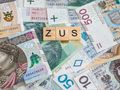 pieniądze i napis ZUS z klocków