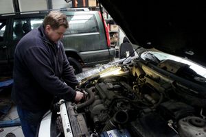 mechanik samochodowy sprawdzający silnik