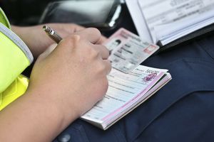 Policjant wypisuje mandat dla kierowcy