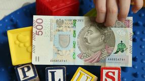 500 zł w rękach dziecka i napis "plus" z klocków