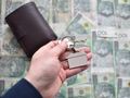 pieniądze i klucze z brelokiem w kształcie domu