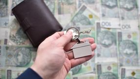 pieniądze i klucze z brelokiem w kształcie domu