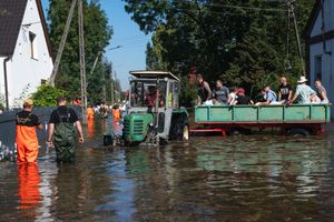 traktor z przyczepą na zalanym terenie