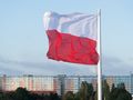 polska flaga na tle bloku mieszkalnego