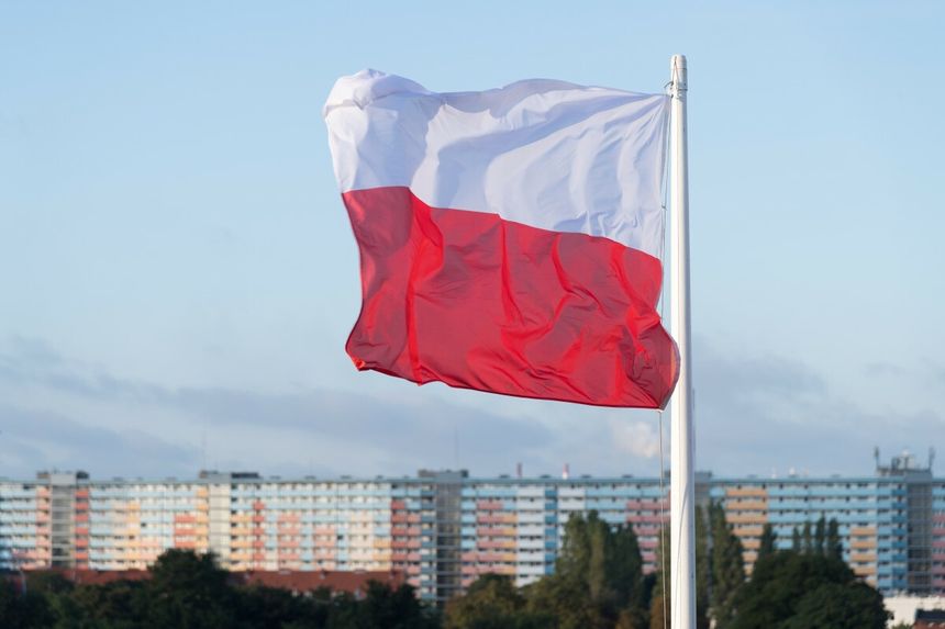 polska flaga na tle bloku mieszkalnego