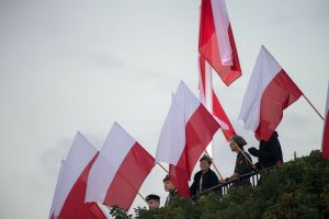 harcerze trzymający polskie flagi na Westerplatte