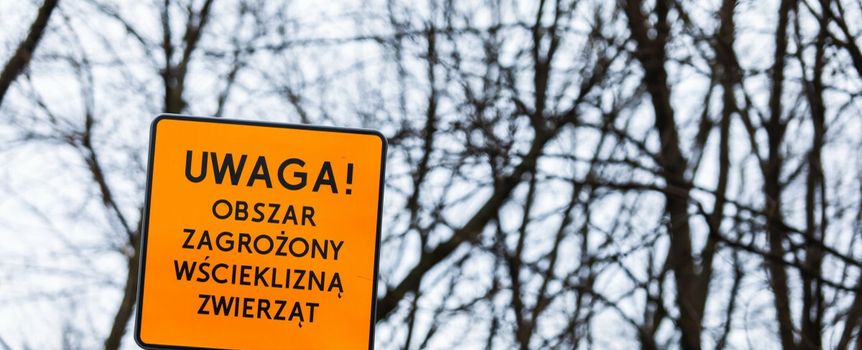 Tablica z napisem Uwaga Obszar zagrożony wścieklizną