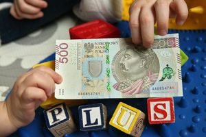 500 zł w rękach dziecka i napis plus z klocków